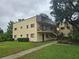 A multi-story home with a lush green lawn, covered balcony, neutral-color scheme, and a welcoming entrance at 11802 Raintree Lake Ln # B, Temple Terrace, FL 33617