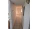 Hallway with tiled flooring leading to a bright entryway and other rooms at 11802 Raintree Lake Ln # B, Temple Terrace, FL 33617