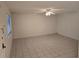 A large living room has tile flooring, a ceiling fan, and window for natural light at 11802 Raintree Lake Ln # B, Temple Terrace, FL 33617