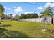 Large, grassy backyard surrounded by a white fence, offering a private outdoor space at 1226 Hermitage Ave, Clearwater, FL 33764