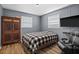 Comfortable bedroom with a black and white checkered bed and wood-look floors and accent furniture at 1226 Hermitage Ave, Clearwater, FL 33764