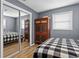 Cozy bedroom featuring a large mirrored closet with decorative Asian style accent furniture and a gray accent wall at 1226 Hermitage Ave, Clearwater, FL 33764