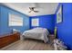 Bright bedroom featuring vibrant blue walls, natural light, and a ceiling fan for added comfort at 1226 Hermitage Ave, Clearwater, FL 33764