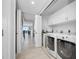 Bright laundry room with modern washer and dryer, and hallway leading to balcony at 1325 Snell Isle Ne Blvd # 810, St Petersburg, FL 33704
