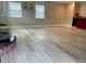 Spacious living room featuring fresh flooring and natural light from multiple windows at 13601 Audrey Ln, Largo, FL 33771