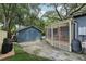 Backyard showcasing a patio, a screened-in porch, and a detached garage, perfect for outdoor living at 1402 E Powhatan Ave, Tampa, FL 33604