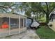 Exterior view showcasing a screened-in porch and patio area perfect for outdoor living at 1402 E Powhatan Ave, Tampa, FL 33604