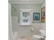 Clean bathroom featuring white subway tiles, mint walls and a bathtub with shower at 1402 E Powhatan Ave, Tampa, FL 33604