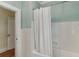 Bathroom with white tiled walls, bathtub and a classic white shower curtain at 1402 E Powhatan Ave, Tampa, FL 33604