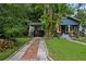 Charming blue home featuring a brick driveway, well-manicured lawn, and covered carport at 1402 E Powhatan Ave, Tampa, FL 33604