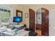 Bright office with a sit-stand desk, hardwood floors, and a custom door at 1402 E Powhatan Ave, Tampa, FL 33604