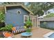 Cozy outdoor patio with striped sofa, chairs and side table, leading to screened-in porch and pool area at 1402 E Powhatan Ave, Tampa, FL 33604