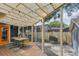 Enclosed patio with dining area, fan, string lights, and outdoor view of the backyard and privacy fence at 1402 E Powhatan Ave, Tampa, FL 33604
