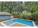 Refreshing backyard pool with wood deck, tiled edge and lush landscaping for a private outdoor retreat at 1402 E Powhatan Ave, Tampa, FL 33604