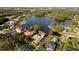 Stunning aerial view of a community with a lake, showcasing beautiful homes and mature trees at 15104 Azra Dr, Odessa, FL 33556