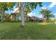Well-manicured lawn gently slopes to a tranquil lake, surrounded by mature trees and lush landscaping at 15104 Azra Dr, Odessa, FL 33556
