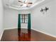 Bedroom features hardwood floors, ceiling fan, large window with curtains, and pre-installed TV mount at 15104 Azra Dr, Odessa, FL 33556