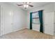 Cozy bedroom featuring a ceiling fan, a window with blinds, and two doors at 15104 Azra Dr, Odessa, FL 33556