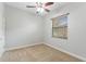 This bedroom boasts neutral walls and carpet, plus a ceiling fan and a window with blinds at 15104 Azra Dr, Odessa, FL 33556