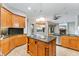 Spacious kitchen with wood cabinetry, granite countertops, stainless steel appliances, and large center island at 15104 Azra Dr, Odessa, FL 33556
