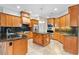 Gourmet kitchen with granite counters, wood cabinets, center island and stainless steel appliances at 15104 Azra Dr, Odessa, FL 33556