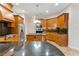 Kitchen with stainless steel appliances, granite countertops, wood cabinets, and island with cooktop at 15104 Azra Dr, Odessa, FL 33556