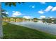 Scenic lake view with a fountain surrounded by lush green grass and clear blue skies, a serene setting at 15104 Azra Dr, Odessa, FL 33556