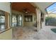 Relaxing screened-in outdoor kitchen with ceiling fan, bar, grill, and stone flooring for ultimate outdoor experience at 15104 Azra Dr, Odessa, FL 33556