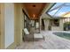 Covered lanai featuring travertine pavers, an outdoor lounge chair, and an outdoor kitchen at 15104 Azra Dr, Odessa, FL 33556