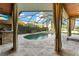 Screened-in pool area featuring travertine pavers, a lagoon-style pool with spa, and an outdoor kitchen at 15104 Azra Dr, Odessa, FL 33556
