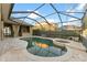 Screened-in pool area featuring travertine pavers, a lagoon-style pool with spa, and an outdoor kitchen at 15104 Azra Dr, Odessa, FL 33556
