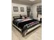 This bedroom offers soft neutral colors, laminate floors, a bed and fireplace at 1600 Still River Dr, Venice, FL 34293