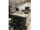Modern kitchen with a granite island, stylish bar stools, and sleek appliances at 1600 Still River Dr, Venice, FL 34293