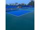 Multiple blue and green outdoor pickleball courts with nets and shaded seating are ready for play at 1600 Still River Dr, Venice, FL 34293