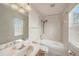 Bright bathroom with shower-tub combo, large mirror, and natural light at 1605 Acorn Seed Ct, Valrico, FL 33594