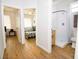 Hallway view of the bedroom and bathroom featuring modern white finishes and hardwood flooring at 1933 Oxnard Ct, Tampa, FL 33612