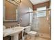 Bathroom with a pedestal sink, tiled shower with glass doors, and warm brown walls at 21215 Preservation Dr, Land O Lakes, FL 34639
