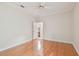 A bright bedroom featuring hardwood floors, white trim, and an open door at 21215 Preservation Dr, Land O Lakes, FL 34639