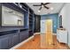 Stylish bedroom featuring hardwood floors, a ceiling fan, and a blue accent wall at 21215 Preservation Dr, Land O Lakes, FL 34639