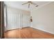 Bright bedroom featuring hardwood floors, a ceiling fan, a window with curtains, and closet doors at 21215 Preservation Dr, Land O Lakes, FL 34639