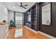 Cozy room featuring hardwood floors, built-in shelves, modern ceiling fan, and natural light through the window at 21215 Preservation Dr, Land O Lakes, FL 34639