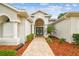 Elegant home entrance with double doors and beautifully landscaped walkway at 21215 Preservation Dr, Land O Lakes, FL 34639