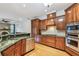 Kitchen features custom wood cabinets, stainless appliances, granite counters and access to living space with fireplace at 21215 Preservation Dr, Land O Lakes, FL 34639