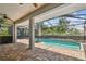 Inviting screened-in pool area with brick patio, lush landscaping, and comfortable outdoor seating at 21215 Preservation Dr, Land O Lakes, FL 34639
