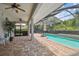 Inviting screened-in pool area with brick patio, lush landscaping, and comfortable outdoor seating at 21215 Preservation Dr, Land O Lakes, FL 34639