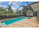 A backyard pool in screened enclosure with patio and an umbrella for shade at 21215 Preservation Dr, Land O Lakes, FL 34639
