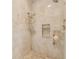 Walk-in shower with beige tile surround, including a handheld showerhead and built-in shelving at 21215 Preservation Dr, Land O Lakes, FL 34639