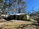 Backyard view displaying home with small patio, mature trees, and a partial fence line at 2221 York S St, Gulfport, FL 33707