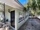 A quaint home exterior featuring a black door, multiple windows, and a cozy side patio area at 2221 York S St, Gulfport, FL 33707
