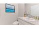 Well-lit half-bath features a modern vanity with a granite countertop and sleek fixtures at 2257 Sienna Spruce St, Wesley Chapel, FL 33543